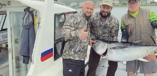 Гости с пойманным тунцом у катера